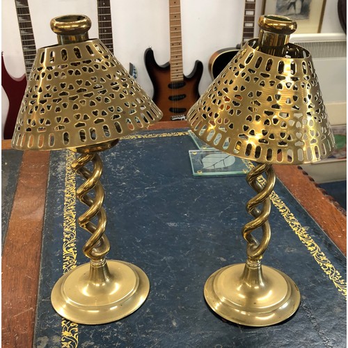 6186 - A pair of brass storm candlesticks with matching brass pierced shades.