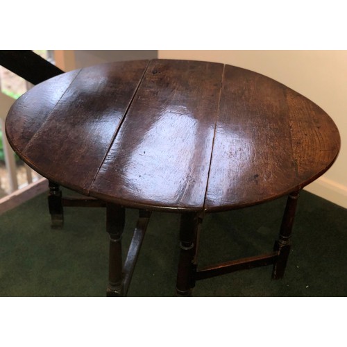 7087 - An oval topped drop leaf oak occasional table on turned legs, 62cm high, top when open 91cm x 104cm.... 