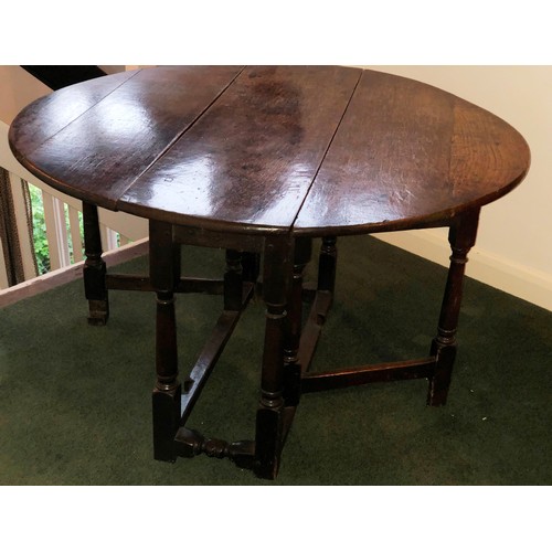 7087 - An oval topped drop leaf oak occasional table on turned legs, 62cm high, top when open 91cm x 104cm.... 