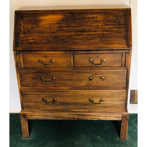 7075 - An oak bureau with fall front enclosing inner cubby holes, 2 short drawers, 2 long drawers with bras... 