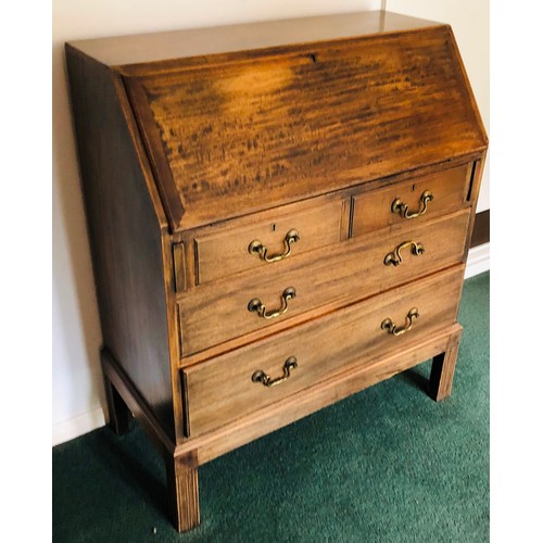 7075 - An oak bureau with fall front enclosing inner cubby holes, 2 short drawers, 2 long drawers with bras... 