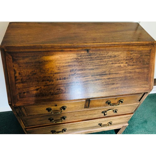 7075 - An oak bureau with fall front enclosing inner cubby holes, 2 short drawers, 2 long drawers with bras... 