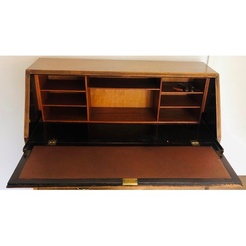 7075 - An oak bureau with fall front enclosing inner cubby holes, 2 short drawers, 2 long drawers with bras... 