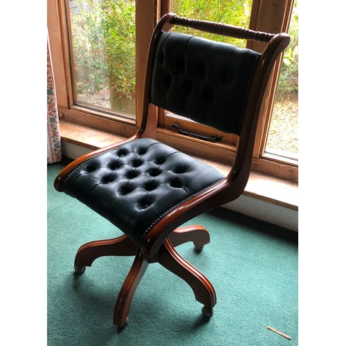 7063 - A reproduction desk chair with green leather seat and back, on castors, 96cm high. (not held by PFW)