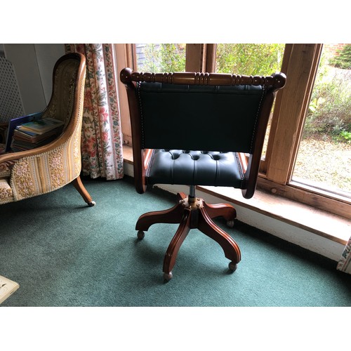 7063 - A reproduction desk chair with green leather seat and back, on castors, 96cm high. (not held by PFW)