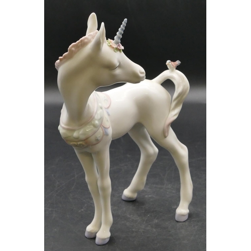 10 - A Lladro figure of a unicorn with a bird on its tail, 23.5cm high