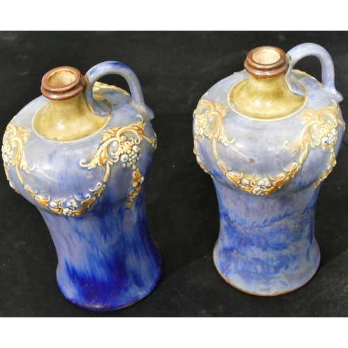 100 - A pair of Royal Doulton round bulbous thin necked jugs on blue ground with raised multicoloured swag... 