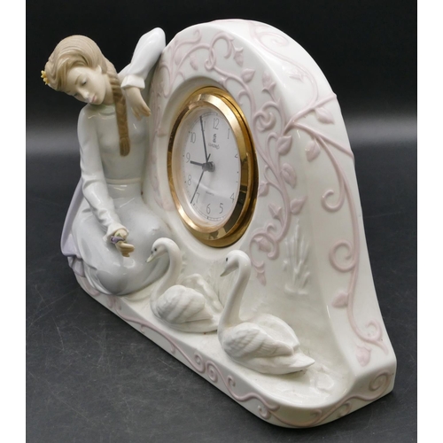 14 - A Lladro clock with raised kneeling young lady and 2 swans, white enamel dial with Arabic numerals, ... 