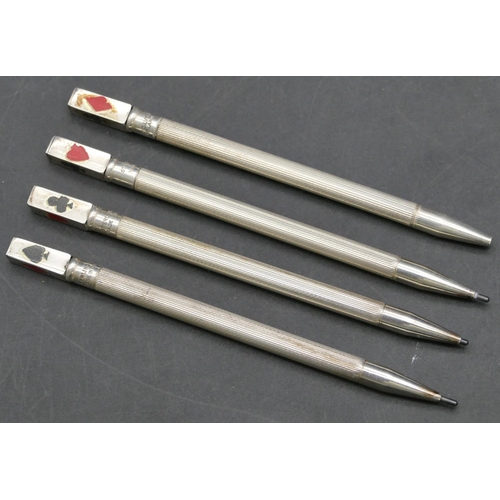 143 - A set of 4 Sterling silver bridge propelling pencils with enamelled club suites decoration in fitted... 