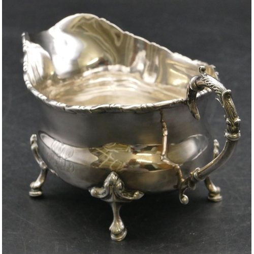 151 - A Birmingham silver bulbous shaped milk jug with scroll handle on splayed feet, 4.2oz