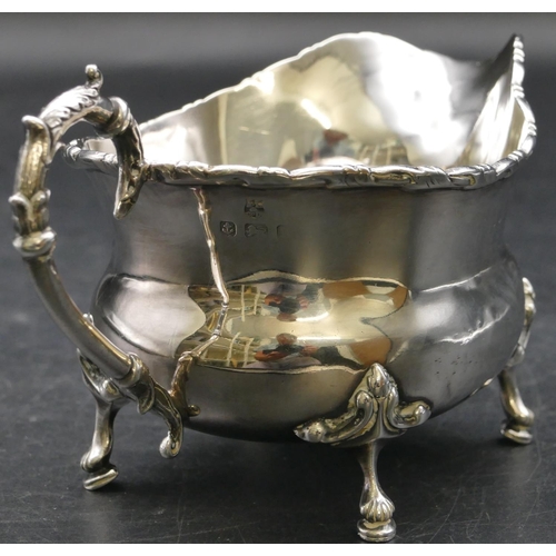 151 - A Birmingham silver bulbous shaped milk jug with scroll handle on splayed feet, 4.2oz