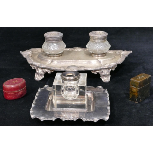 153 - A silver plated and glass inkwell with scallop shaped stand on splayed feet mounted with 2 glass bot... 