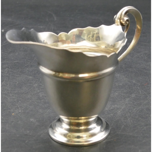 165 - A late Victorian silver cream jug with crinkled rim, scroll handle and splayed base, London 1899, 3.... 