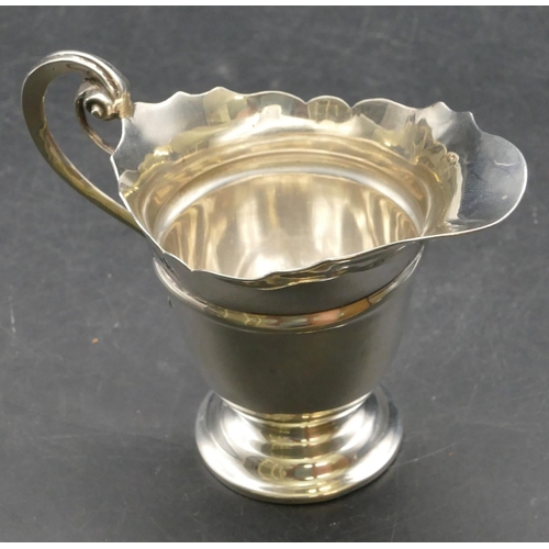 165 - A late Victorian silver cream jug with crinkled rim, scroll handle and splayed base, London 1899, 3.... 