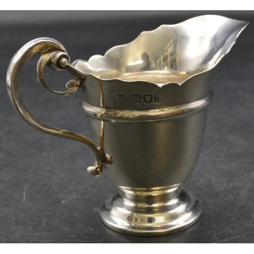 165 - A late Victorian silver cream jug with crinkled rim, scroll handle and splayed base, London 1899, 3.... 