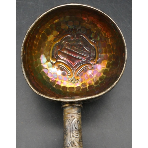 168 - An Eastern silver coloured metal ladle with part embossed leaf and scroll decoration, 47cm long, 6.6... 