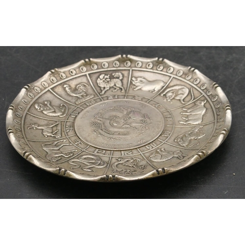 174 - An Oriental small round dish with raised zodiac animals inset with coin, 9.8cm diameter