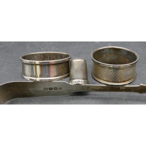 205 - A pair of Victorian silver sugar tongs, 2 silver napkin rings and a silver thimble, 2.5oz (4)