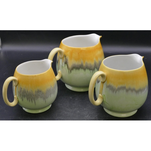 22 - A set of 3 Shelley graduated round bulbous shaped dripware jugs on pale green and yellow ground, lar... 