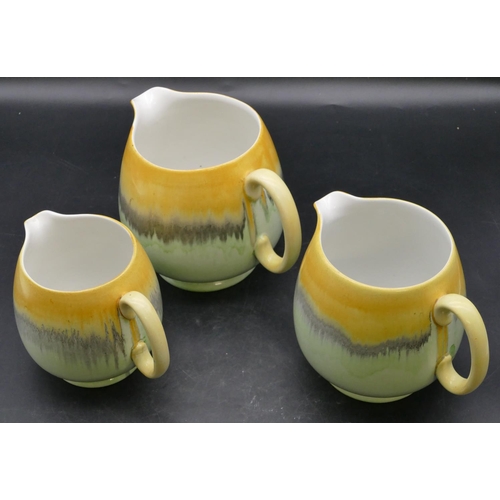 22 - A set of 3 Shelley graduated round bulbous shaped dripware jugs on pale green and yellow ground, lar... 