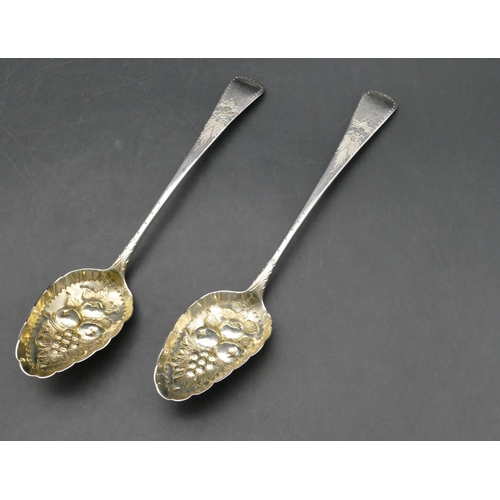 232 - A pair of George III silver berry spoons, embossed bowls with leaf and fruit decoration and engraved... 