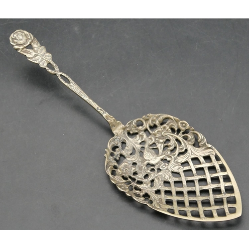 238 - A Dutch silver coloured metal serving spoon with pierced raised bird, floral and scroll decoration, ... 