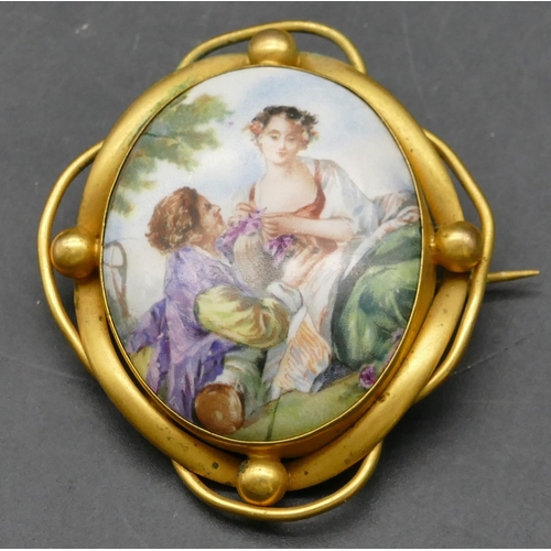 252 - A gilt metal brooch with pierced rim, depicting 2 figures, 5.5cm high