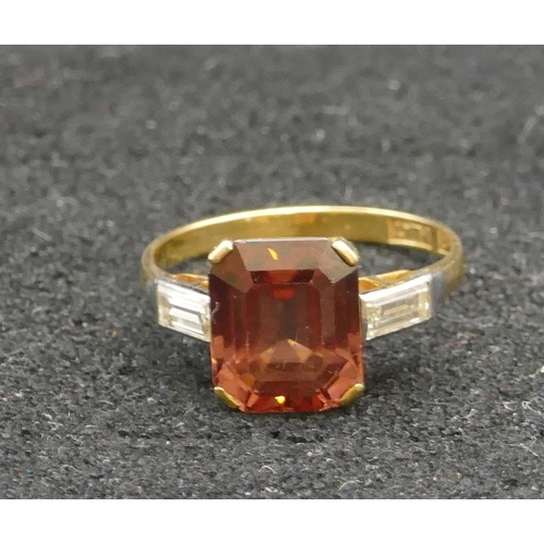 284 - An 18ct gold ladies' ring set with pale garnet and mounted with bagutte diamonds to shoulders, Size ... 