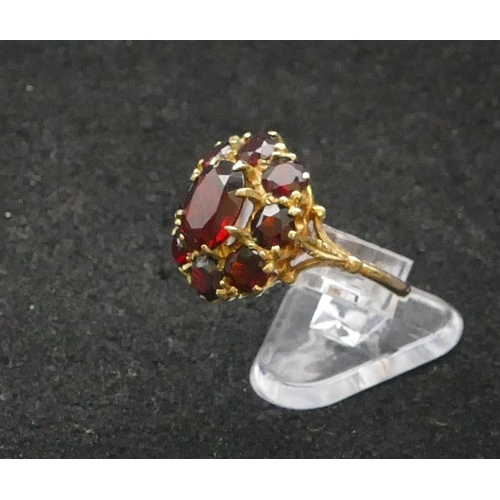 292 - A 9ct gold oval cluster ring set with centre garnet surrounded by 8 smaller garnets, Size P, 4 grams... 