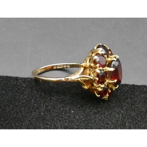 292 - A 9ct gold oval cluster ring set with centre garnet surrounded by 8 smaller garnets, Size P, 4 grams... 