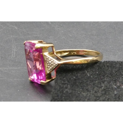 293 - A 9ct gold pink topaz ring flanked by small diamond chips, Size R, 4.4 grams gross