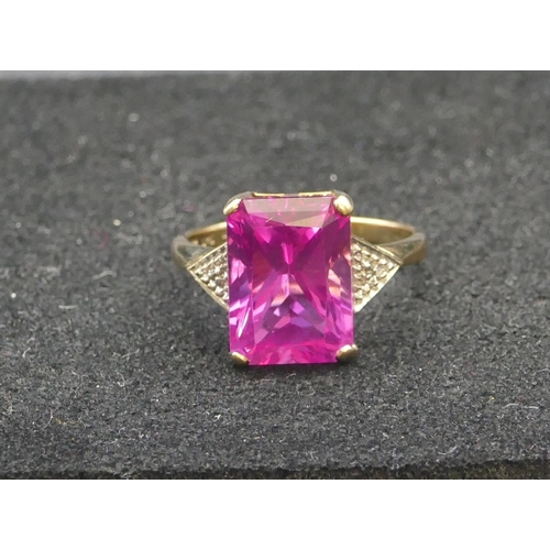 293 - A 9ct gold pink topaz ring flanked by small diamond chips, Size R, 4.4 grams gross