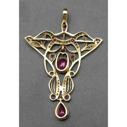 296 - A 14ct gold drop pendant with allover pierced decoration mounted with red stones allover diamond chi... 