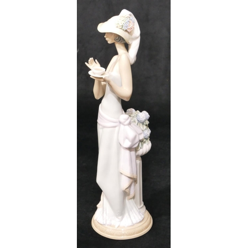 35 - A Lladro figure of a standing lady holding cup of tea and wearing floral bonnet, 36.5cm high (boxed)