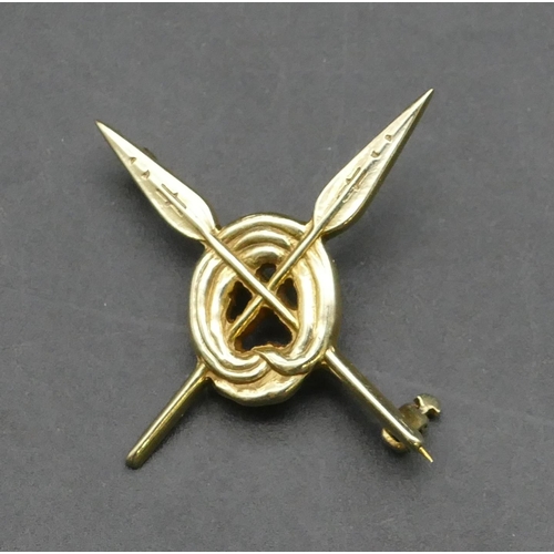 356 - A 14ct gold brooch in the form of 2 crossed spears mounted through a circle, 3.5cm wide, 4.4 grams