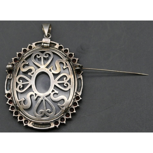 358 - A 925 silver oval pendant/brooch with cut steel and red stones to rim, 7.7cm high