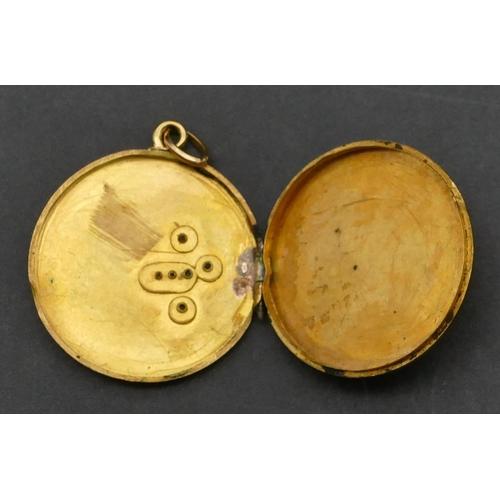 379 - A circular gold locket with bird motif, 4 grams