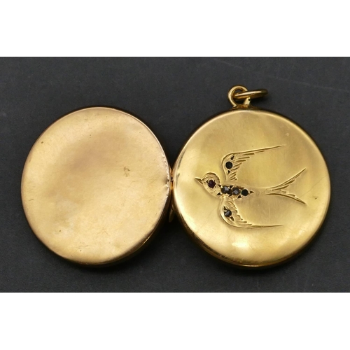 379 - A circular gold locket with bird motif, 4 grams