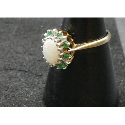 407 - A 9ct gold oval cluster ring set with centre opal, surrounded by small emeralds and diamond chips, (... 