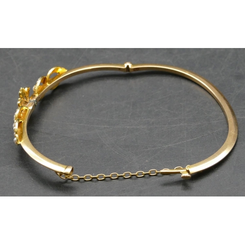 417 - A gold hinged bangle with raised Mother of Pearl motifs, 9.5 grams