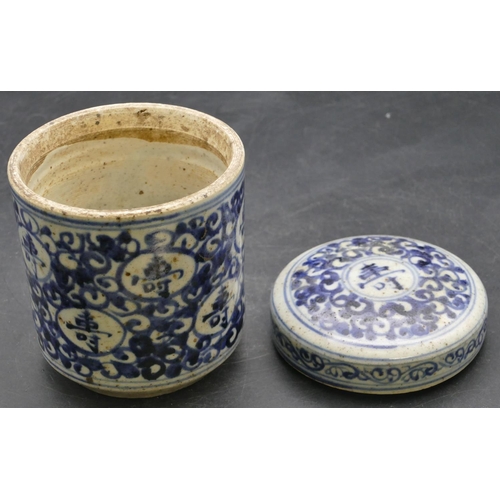 42 - An Oriental cylindrical lidded pot on blue and white ground with scroll decoration, 12.5cm high