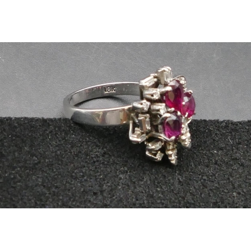 430 - An 18ct white gold ladies' cluster ring set with 3 rubies interspersed by various shaped diamonds, S... 