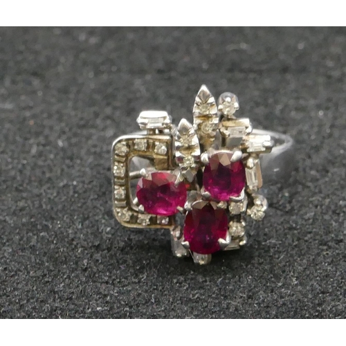 430 - An 18ct white gold ladies' cluster ring set with 3 rubies interspersed by various shaped diamonds, S... 