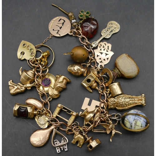 434 - A 9ct gold charm bracelet mounted with 33 various gold and other charms, 55.2 grams gross