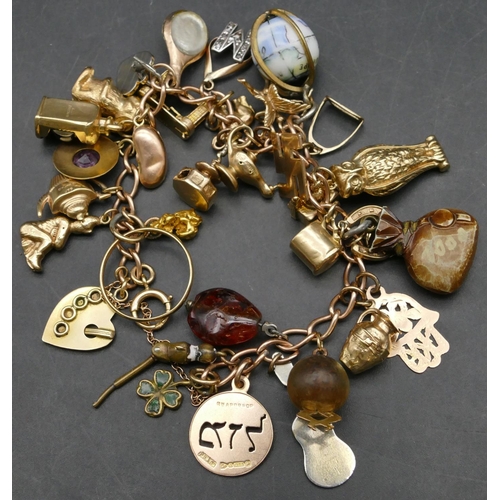 434 - A 9ct gold charm bracelet mounted with 33 various gold and other charms, 55.2 grams gross