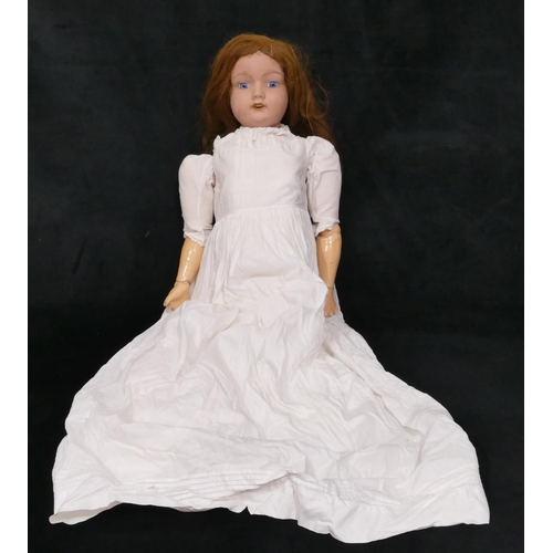 492 - A large porcelain headed doll with open eyes and mouth, jointed body, 83cm long overall