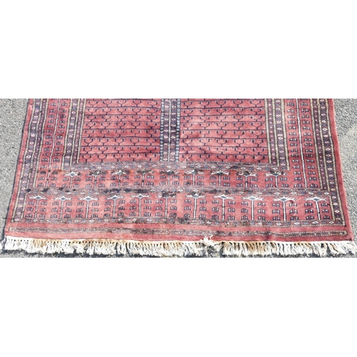 516 - A modern wool Bokhara rug on red ground with 4 centre medallions, 228cm x 154cm