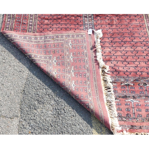 516 - A modern wool Bokhara rug on red ground with 4 centre medallions, 228cm x 154cm