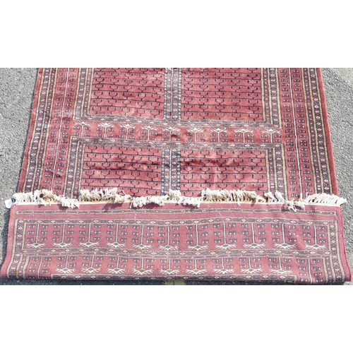 516 - A modern wool Bokhara rug on red ground with 4 centre medallions, 228cm x 154cm