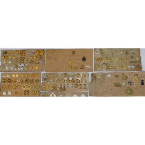 553 - 200 various military and other cap badges and lapel/collar badges all mounted on 11 cardboard panels